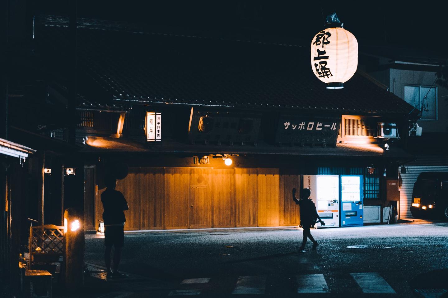 My wife and I were taking a late-night walk around Gujo, Japan. I snapped this shot of a boy greeting a man. I'm not sure what their relationship was, but I hope the kid wasn't just coming home from school.