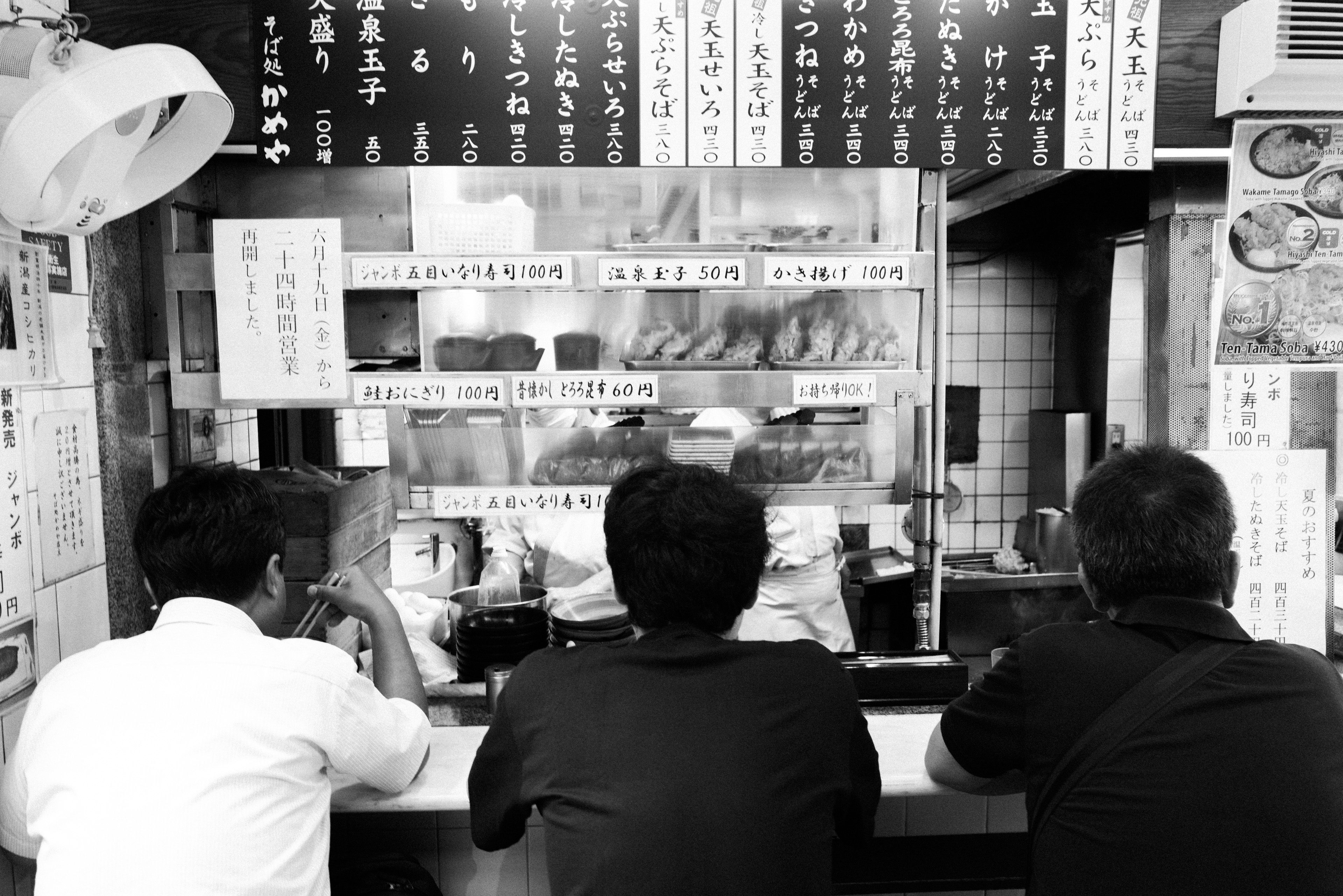 Three men eating ramen in Shinjuku.